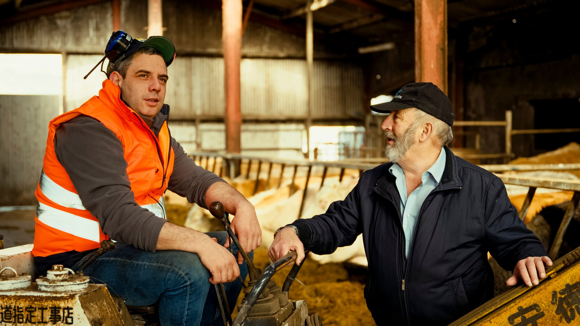 Danny Healy-Rae talking with a young farmer in a cattle shed