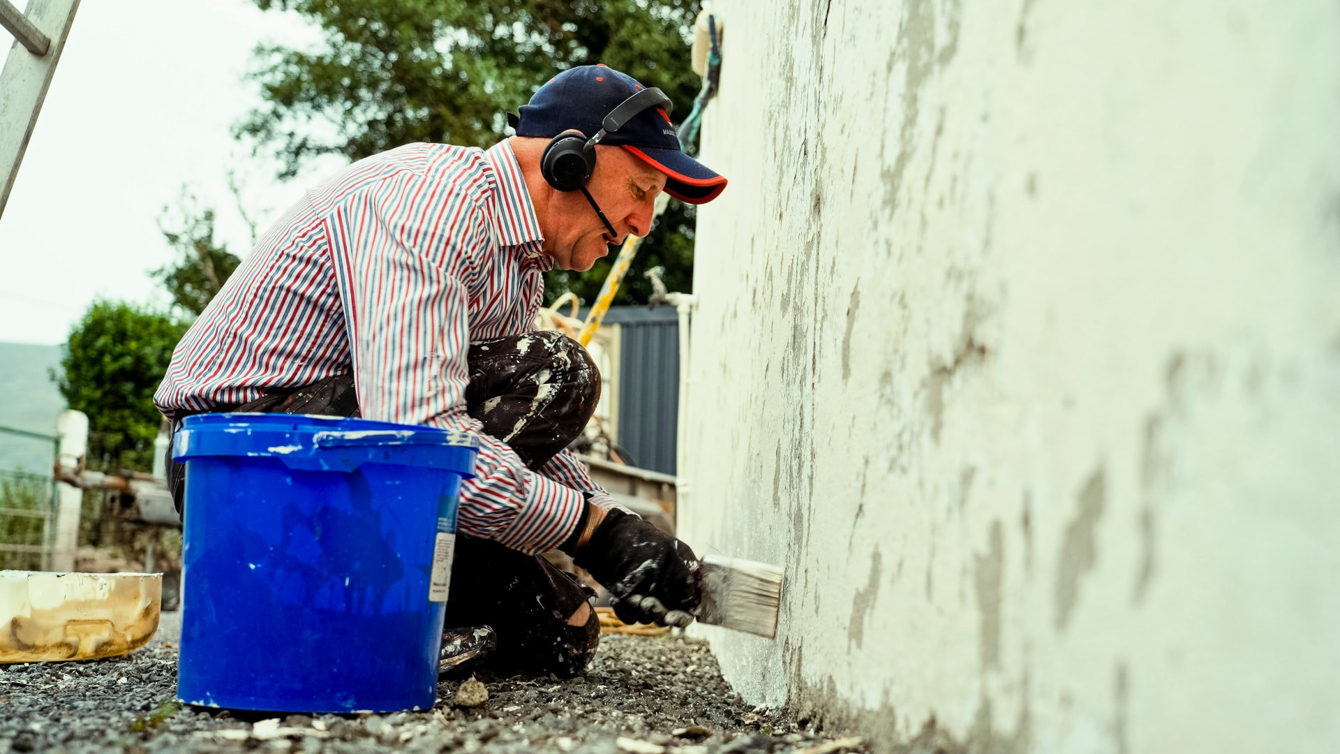 A tradesman painting the wall of a rural Kerry building